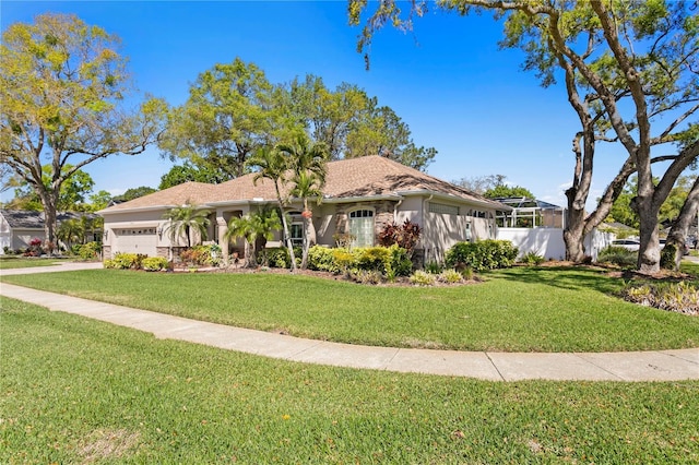 view of front of house featuring a front yard, an attached garage, and stucco siding