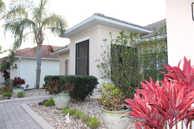 view of home's exterior with stucco siding and a tile roof