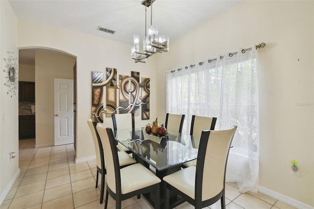 dining area with visible vents, arched walkways, light tile patterned floors, baseboards, and a chandelier