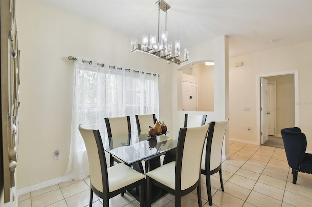 dining room with light tile patterned floors, a notable chandelier, and baseboards