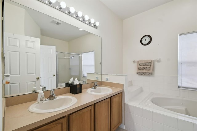 full bath featuring double vanity, a stall shower, visible vents, and a sink