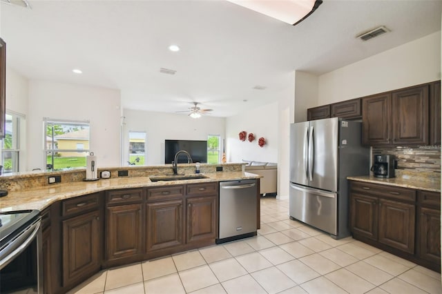 kitchen with visible vents, a sink, appliances with stainless steel finishes, light tile patterned flooring, and decorative backsplash