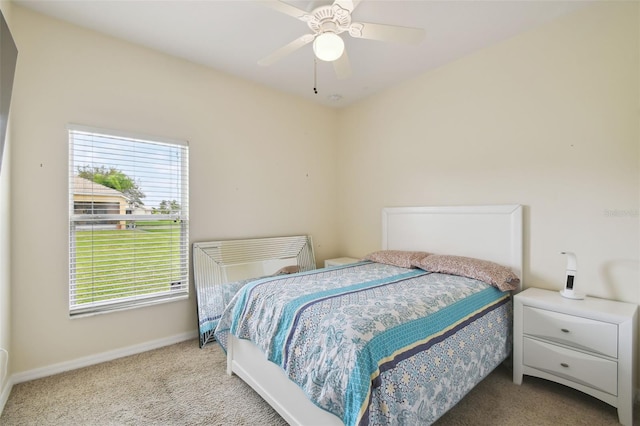 carpeted bedroom with a ceiling fan and baseboards