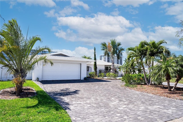 ranch-style house with stucco siding, decorative driveway, and an attached garage