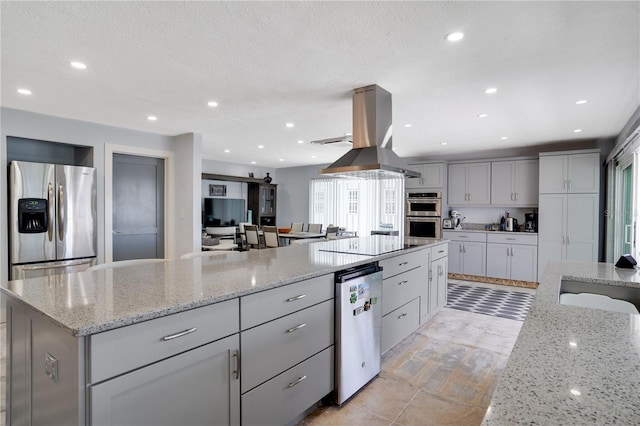 kitchen with light stone counters, recessed lighting, island exhaust hood, and appliances with stainless steel finishes