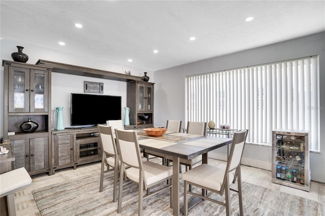 dining room with recessed lighting, baseboards, a textured ceiling, and beverage cooler