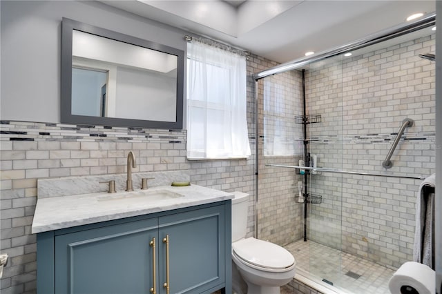 full bath with tile walls, a shower stall, toilet, and vanity