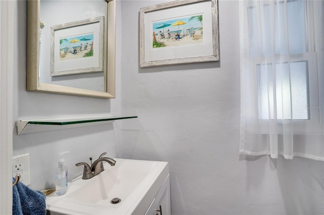 bathroom featuring vanity and a textured wall