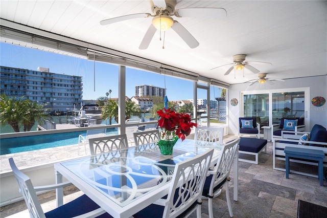 sunroom featuring a city view and ceiling fan