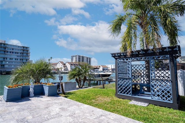 exterior space featuring a lawn, fence, a boat dock, and a water view