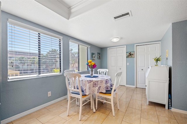 dining room featuring visible vents, a textured ceiling, and baseboards