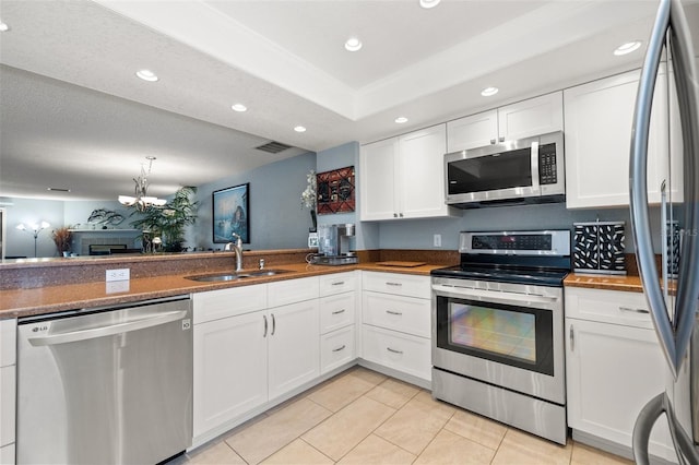 kitchen with light tile patterned floors, recessed lighting, appliances with stainless steel finishes, white cabinetry, and a sink