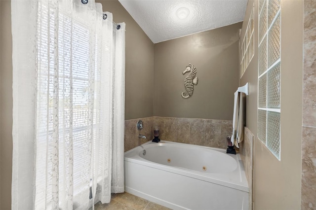 bathroom featuring tile patterned floors, a whirlpool tub, and a textured ceiling