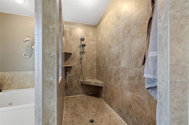 full bath featuring a tub with jets, a textured ceiling, and tiled shower