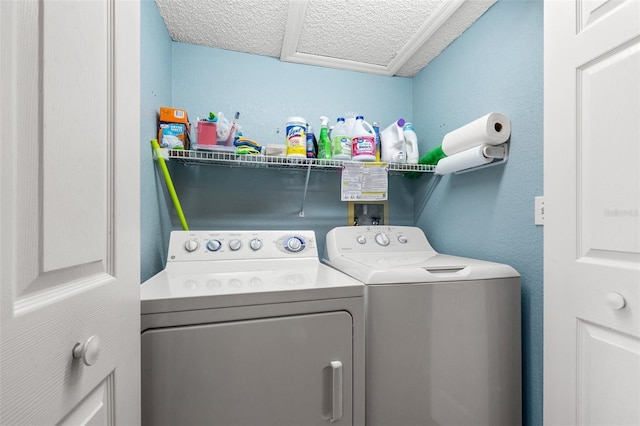 washroom with washer and clothes dryer, laundry area, and a textured ceiling