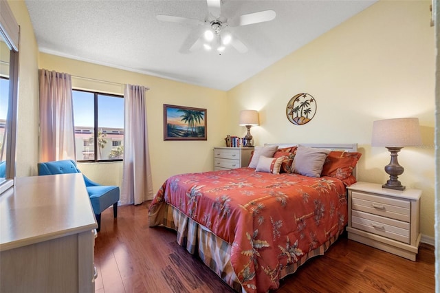 bedroom featuring ceiling fan, lofted ceiling, wood finished floors, and a textured ceiling