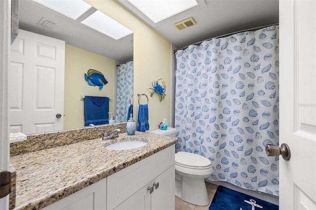 bathroom featuring vanity, toilet, visible vents, and tile patterned flooring