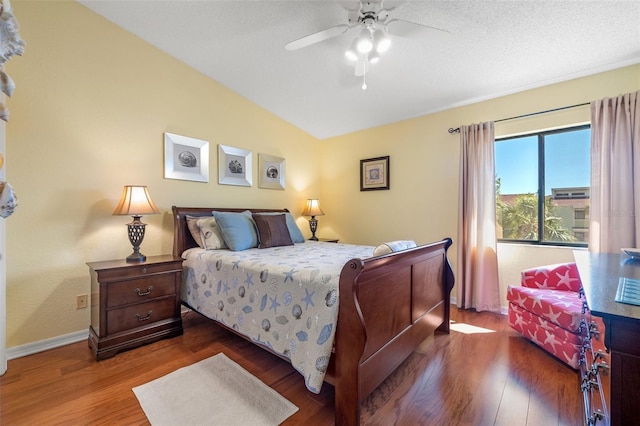 bedroom with lofted ceiling, wood finished floors, baseboards, and ceiling fan