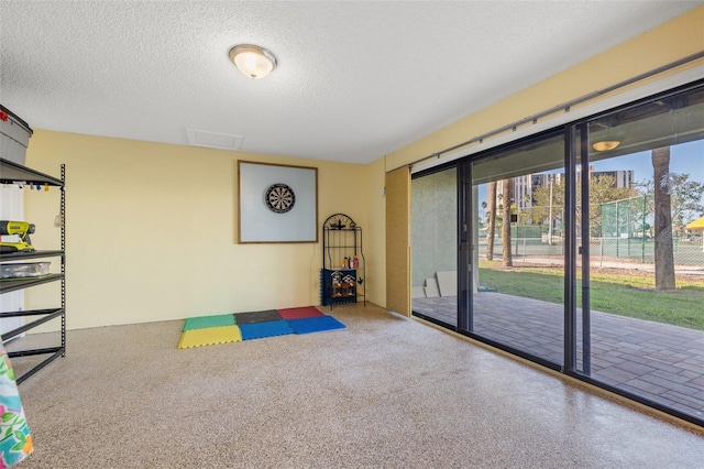 recreation room featuring speckled floor and a textured ceiling