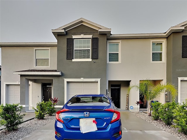 townhome / multi-family property with stucco siding and a garage