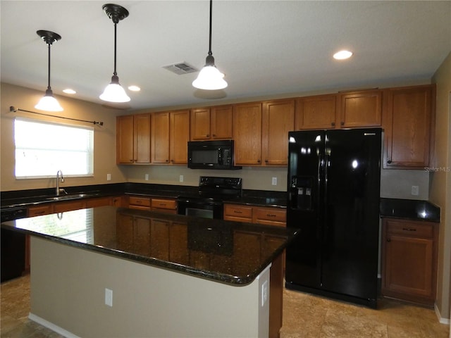 kitchen with brown cabinetry, visible vents, a sink, black appliances, and pendant lighting