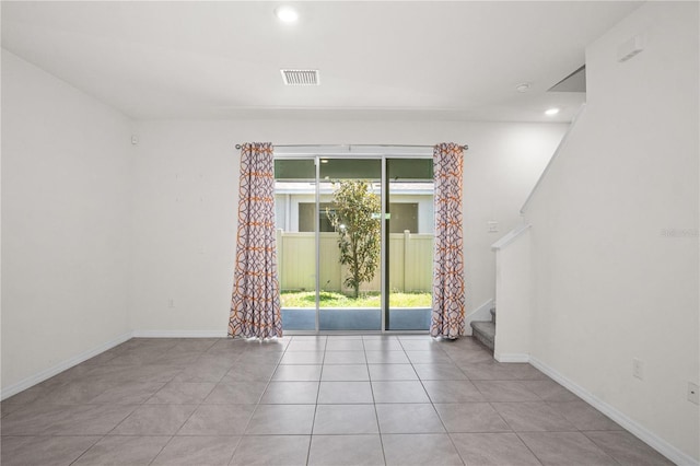 empty room featuring stairway, baseboards, tile patterned floors, and visible vents