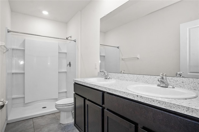 bathroom featuring toilet, tile patterned flooring, a sink, and a stall shower