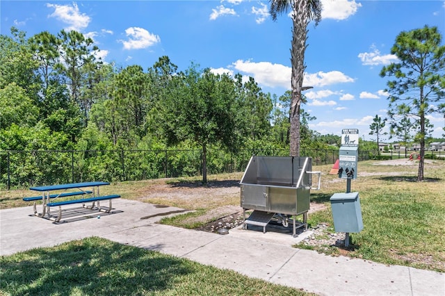 view of home's community with a yard and fence