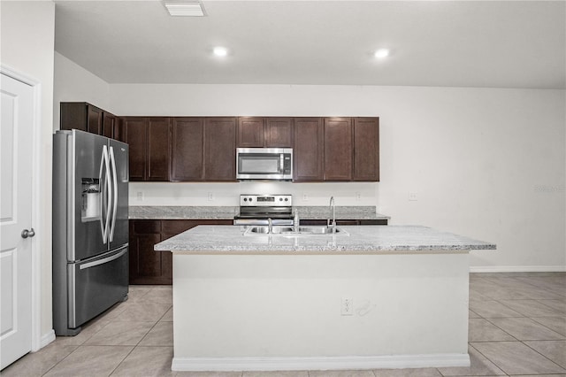 kitchen featuring appliances with stainless steel finishes, a kitchen island with sink, light tile patterned flooring, and visible vents