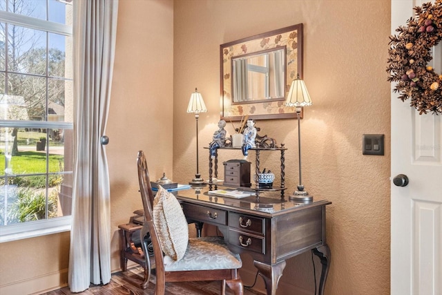 home office with baseboards, wood finished floors, and a textured wall