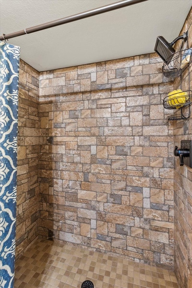 details with a textured ceiling and tiled shower