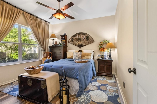 bedroom featuring ceiling fan, baseboards, and wood finished floors