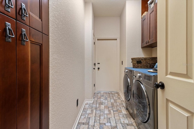 laundry area with washer and dryer, cabinet space, baseboards, and a textured wall