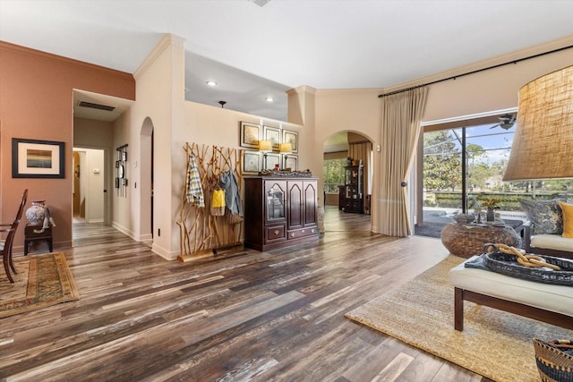 living area featuring visible vents, arched walkways, and dark wood finished floors