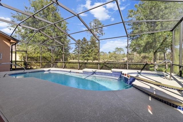 view of pool with a patio area, a pool with connected hot tub, and a lanai