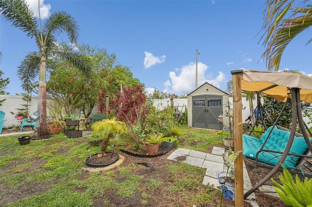 view of yard featuring a storage shed, a fenced backyard, and an outdoor structure