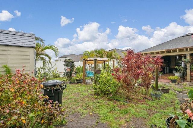 view of yard featuring a storage shed, an outdoor structure, and fence