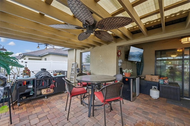 view of patio / terrace with a ceiling fan, outdoor dining area, and fence