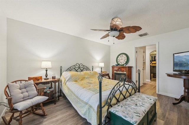 bedroom with visible vents, ceiling fan, baseboards, and wood finished floors