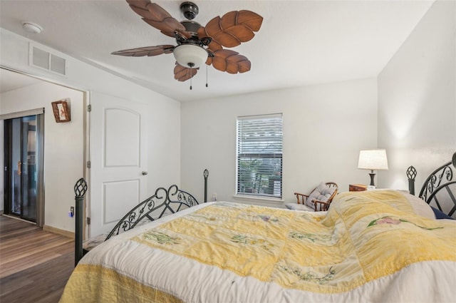 bedroom with visible vents, baseboards, wood finished floors, and a ceiling fan