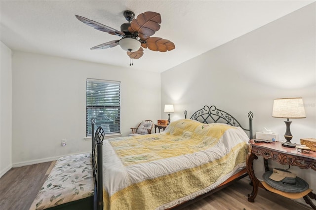 bedroom featuring baseboards, wood finished floors, and a ceiling fan