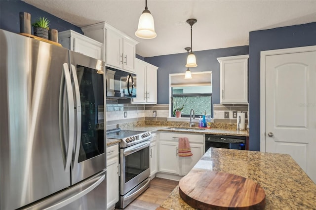 kitchen with a sink, black appliances, and white cabinetry