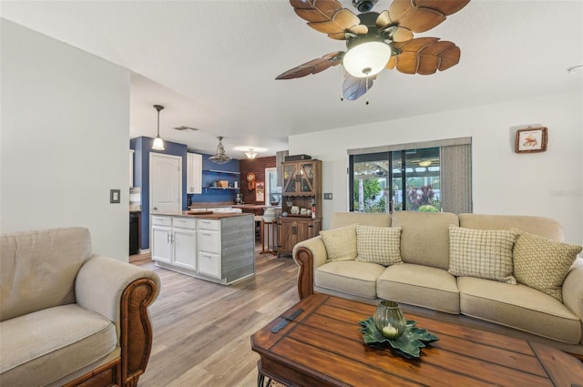 living area with visible vents, ceiling fan, and light wood finished floors