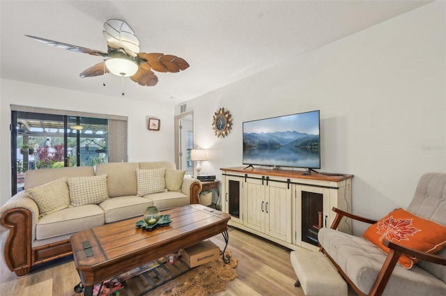 living area with a ceiling fan, visible vents, and light wood finished floors