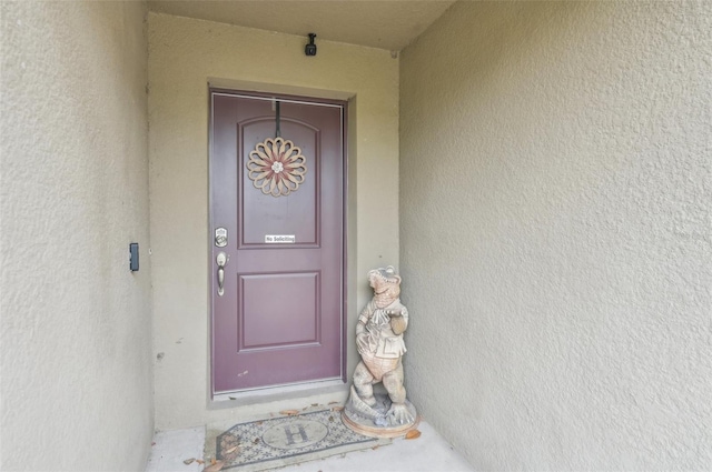 entrance to property with stucco siding