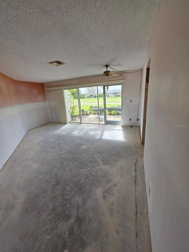 unfurnished living room with visible vents, a textured ceiling, and concrete flooring