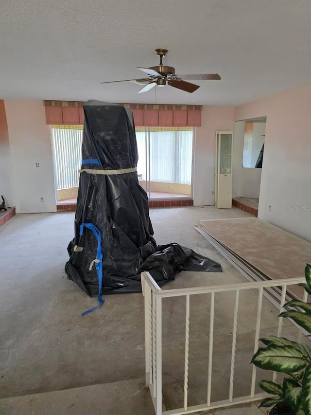 interior space with ceiling fan, a wealth of natural light, and a textured ceiling