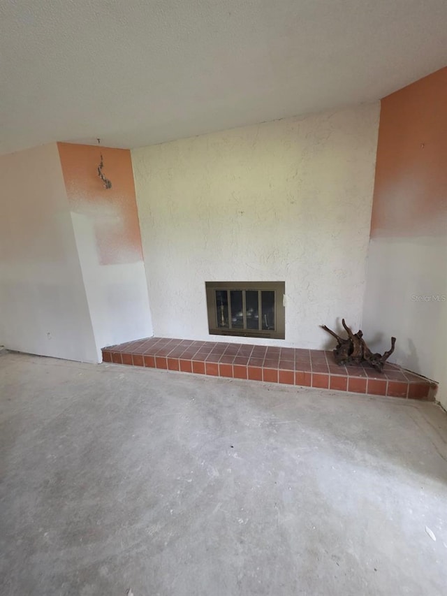 unfurnished living room featuring a fireplace and concrete flooring