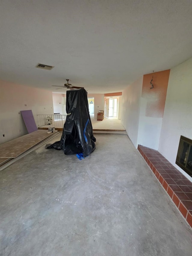 interior space with visible vents, a fireplace, and unfinished concrete flooring