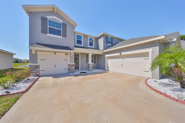 view of front of home featuring a shingled roof, stone siding, driveway, and stucco siding